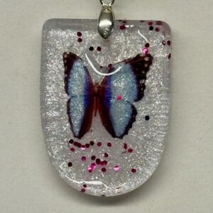 Pendentif demi rond blanc avec un papillon au centre