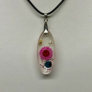 Pendentif forme oblongue transparent avec fleur rose