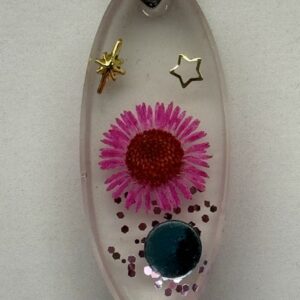 Pendentif forme oblongue transparent avec fleur rose